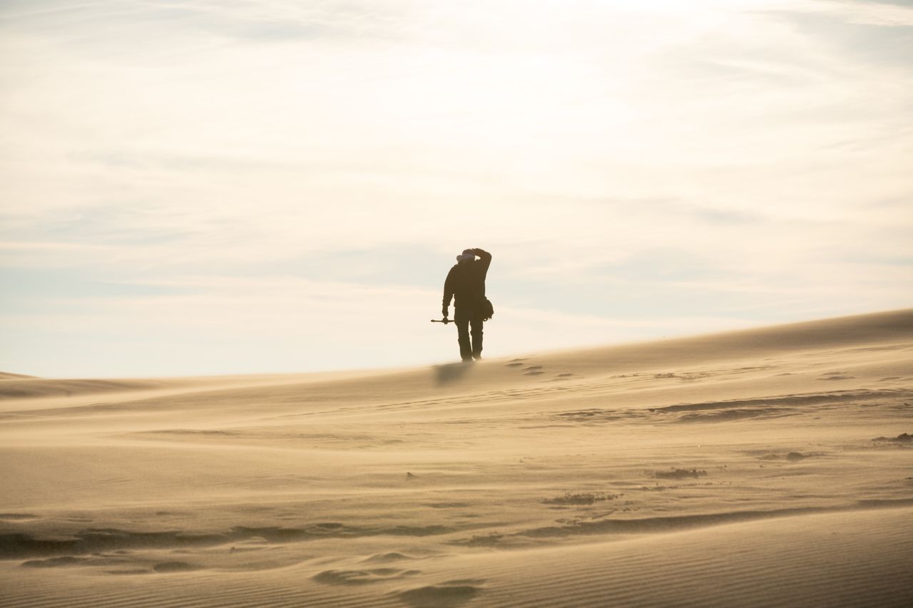 A lone figure walks on the vast sand dunes of Silver Lake, Indiana.