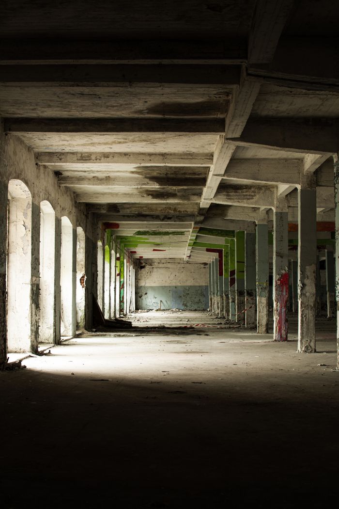 Old Home Explore the eerie stillness of an abandoned warehouse with its haunting pillars and shadowy ambiance.